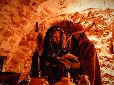 Wiedźma czyta księgę w pomarańczowej krypcie